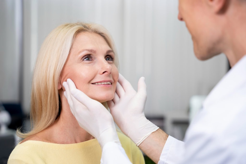 Older woman smiling during cheek treatment