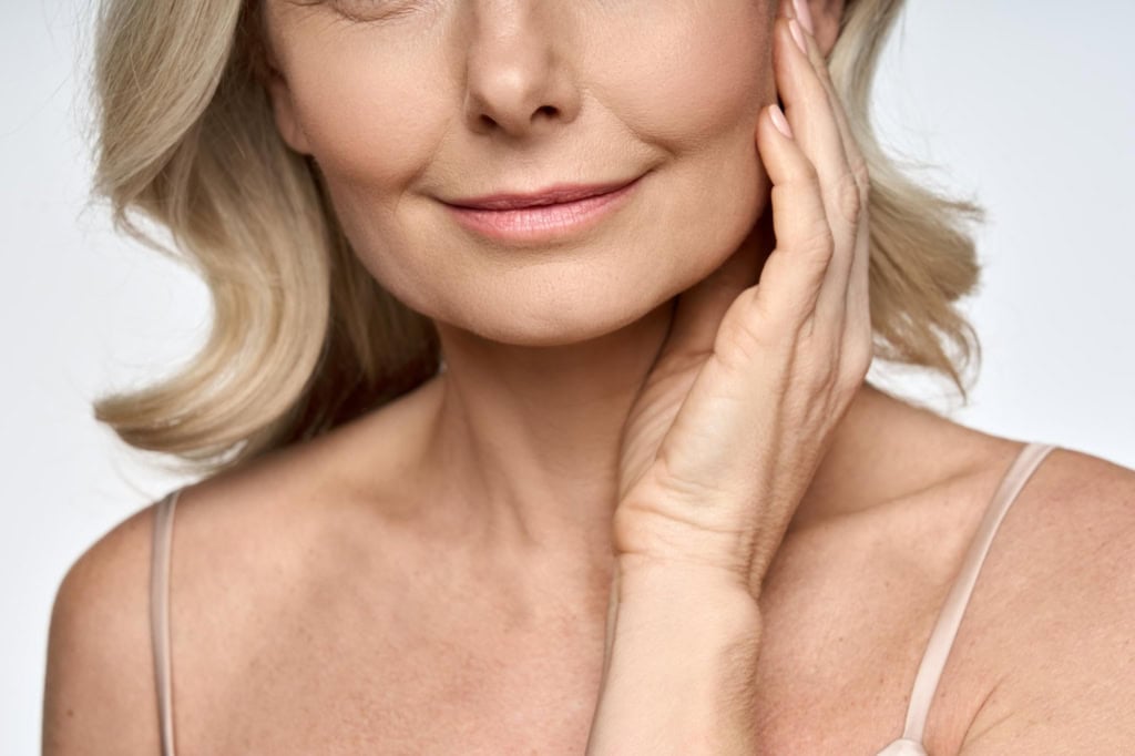 Detailed closeup portrait of face neck and decollete of 50s aged woman